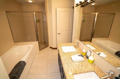 a bathroom with two sinks and a tub and a shower at The Eagle Suite at Stoneridge Mountain Resort in Canmore
