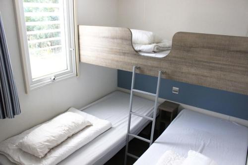 的住宿－Mobilheim 4-5 Personen MH9，带窗户的客房内的两张双层床