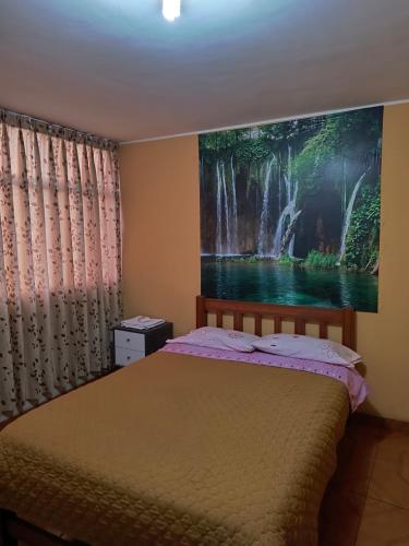 Schlafzimmer mit einem Bett mit Wandgemälde in der Unterkunft Dulces Sueños in Huancayo