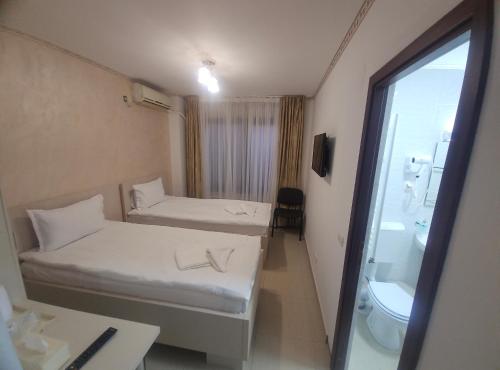 a small room with two beds and a bathroom at Hotel Marina 2 in Bucharest
