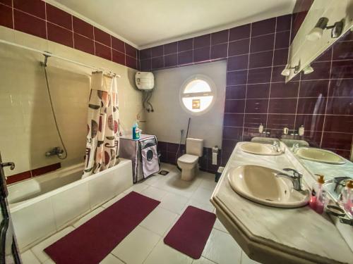 y baño con lavabo, bañera y aseo. en Comfortable 2 BR Apartment in New Cairo's Heart, en El Cairo