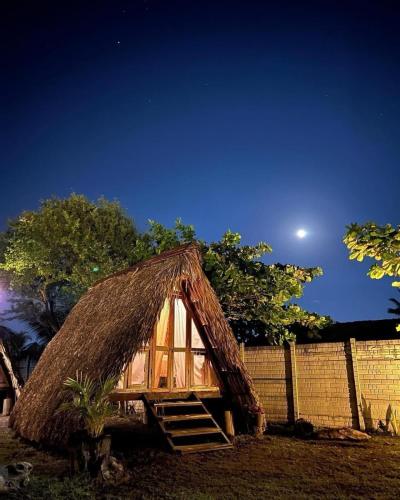 Cabaña pequeña con techo de paja por la noche en Playa Nautilus, en Puerto San José