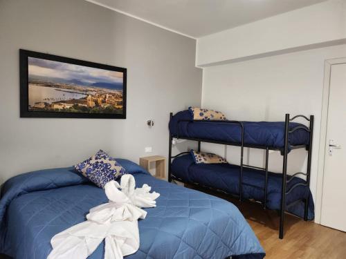 a bedroom with two bunk beds with blue sheets at Milazzo La Porta Delle Eolie 2.0 in Milazzo