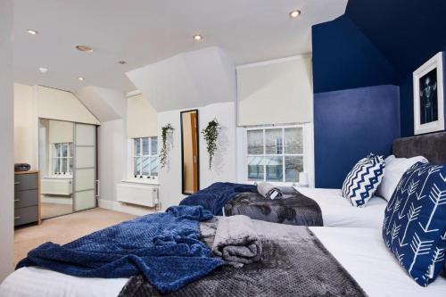 1 dormitorio con 2 camas y paredes azules y blancas en The Beautiful Central Gem Of Bath - Sleeps 24!, en Bath