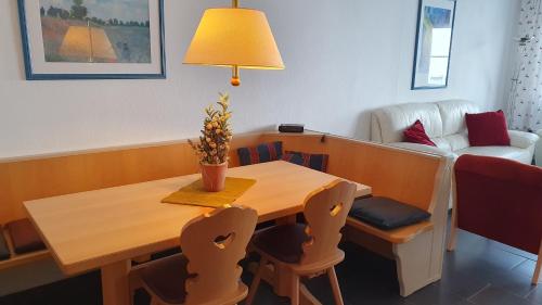 stół jadalny z krzesłami, lampką i kanapą w obiekcie Lechbruck am See Feriendorf Hochbergle Haus 7 w mieście Lechbruck am See