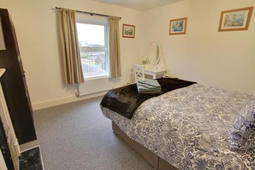 a bedroom with a bed and a mirror and a window at Beautiful Riverside cottage in March