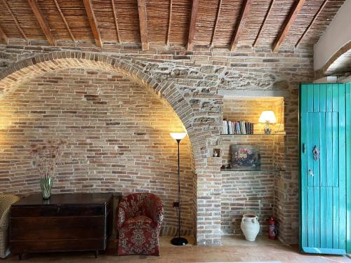 a room with a brick wall with a table and a chair at Villa Antonella in Pisticci
