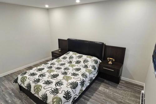 a bedroom with a bed with a black and white comforter at Spacious bright Apt,Parking and self check-in in Longueuil