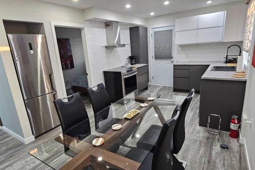 a kitchen with a glass table and black chairs at Spacious bright Apt,Parking and self check-in in Longueuil
