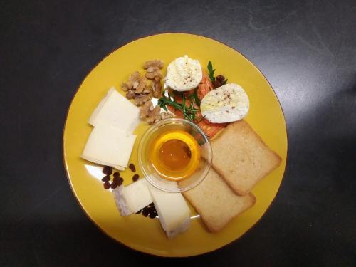 a yellow plate of food with eggs and bread at MOUNTAIN HOTEL Osteria di MONTAGNA La Peonia Monte Generoso in Mendrisio