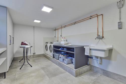 a laundry room with a sink and a washing machine at DAS SALZBERG Hideaway Bad Aussee - Adults only in Bad Aussee