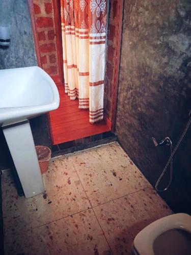 a dirty bathroom with a toilet and a sink at ARA Place - Boossa - Private Villa in Boossa