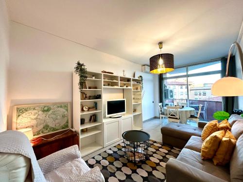 uma sala de estar com um sofá e uma televisão em Apartment Sagrera em Barcelona