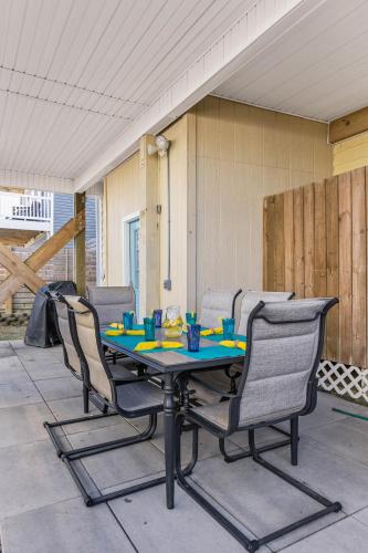 a table and chairs sitting on a patio at Bombastic Home - Steps to Beach - GameRm - Hot Tub - Pet Friendly in Surf City