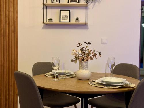 a wooden table with glasses and a vase with flowers at DD Apartments - Mavrovo in Mavrovo