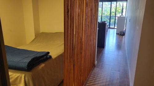 Hermoso apartamento en pocitos في مونتيفيديو: مرآة بجانب سرير في غرفة