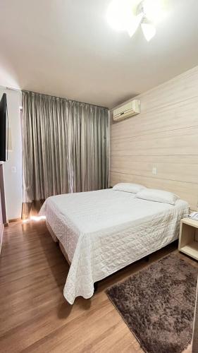 a bedroom with a large white bed and a window at Regente Hotel in Pato Branco