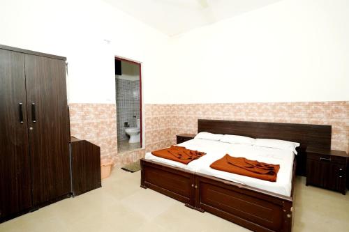 a bedroom with a bed and a bathroom with a toilet at Muruz Stay Inn in Gūdalūr