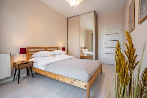 a bedroom with a large bed and a mirror at Apartamenty Tespis - Francuska Atal Park in Katowice