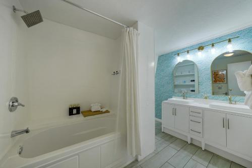 Baño blanco con bañera y lavamanos en Family Oasis With Pool Firepit Minigolf and Climbing Dome, en Panama City Beach