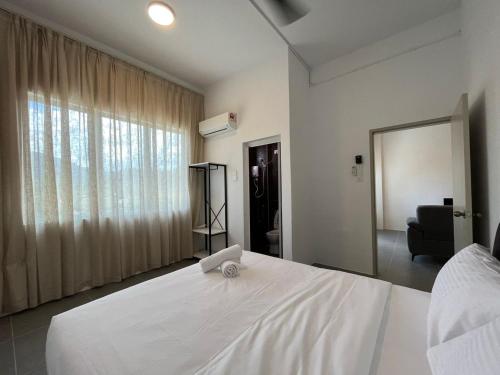 - une chambre avec un lit blanc et un ordinateur portable dans l'établissement Langkawi - Simfoni Beliza Homestay, à Kuah