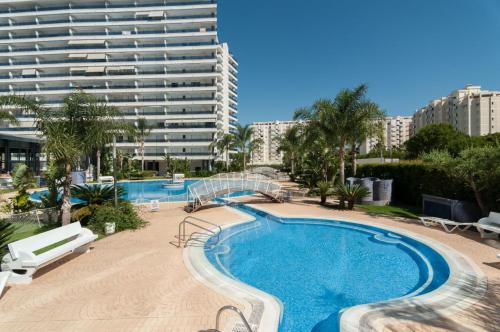 een zwembad voor een groot gebouw bij AG RESIDENCIAL EL EDEN in Playa de Gandia