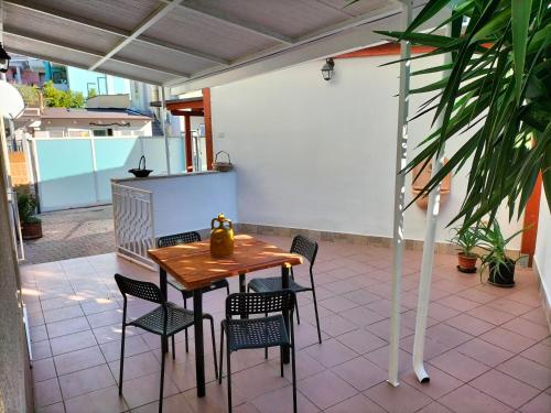 Une table et des chaises en bois sont disponibles sur la terrasse. dans l'établissement SWEET HOME alternativo all'appartamento, à Pescara