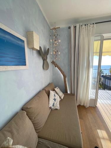 sala de estar con sofá y ventana en Trilocale pregiato sul mare, en San Bartolomeo al Mare