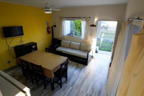 a living room with a table and a couch at Etels House - Departamentos Mina Clavero in Mina Clavero