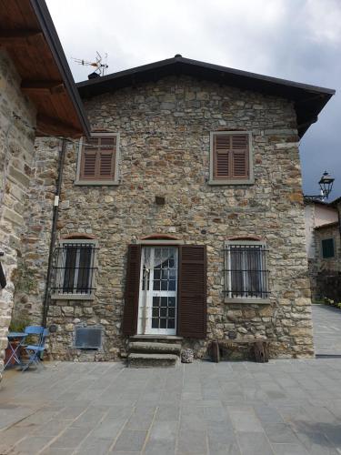 a stone building with windows and a door at Case Apuane in Minucciano