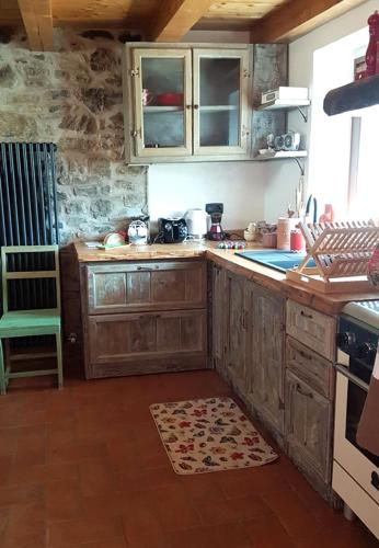 a kitchen with wooden cabinets and a stove at Case Apuane in Minucciano