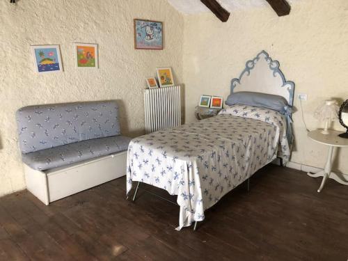 1 dormitorio con cama y banco. en Suggestivo casale in collina, en Cassano