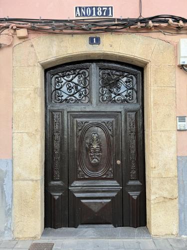 a large wooden door with a face on it at HAPPYVILA Apartments in Villajoyosa
