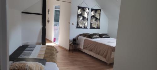 a bedroom with two beds and two pictures on the wall at Pascal et Domi CHAMBRES "l'oasis des pins" in Chateau-l'Hermitage