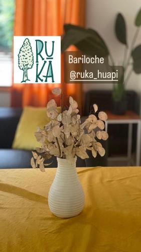 een witte vaas met bloemen op een tafel bij Cabaña Lago Nahuel Huapi - Bariloche in Bariloche