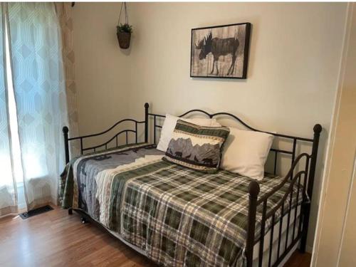 a bedroom with a bed with a plaid blanket at Rise and Shine! A Gorge-ous cabin! in Korea