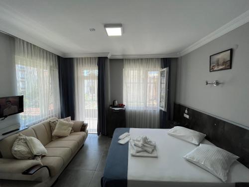 uma sala de estar com uma cama e um sofá em Lara Hakan Family Apart em Antalya
