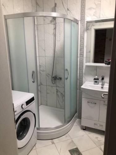 a bathroom with a shower and a washing machine at Queen's luxury Apartment in Ohrid