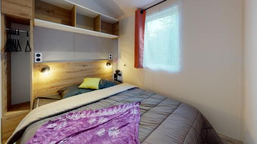 a small bedroom with a bed and a window at Camping Capfun La Bretèche in Les Épesses