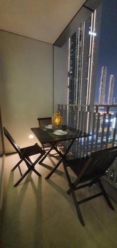 a table and chairs in a room with a view of a city at SVIZONA Premium 2BHK, Burj Khalifa View, Downtown Dubai in Dubai