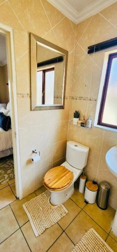 a bathroom with a toilet and a mirror and a sink at A Warm 3 bed Townhouse in a secure complex in Witbank