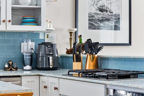 a kitchen counter with a stove top and blue tiles at Bombastic Home - Steps to Beach - GameRm - Hot Tub - Pet Friendly in Surf City