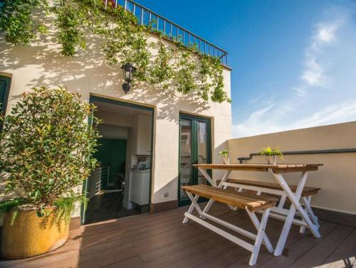 a wooden table and a bench on a patio at Apartamentos Cruz in Madrid