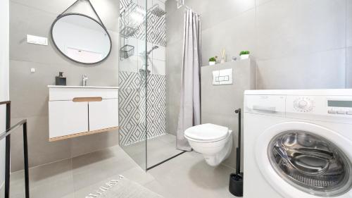 ein Badezimmer mit einer Waschmaschine und einem WC in der Unterkunft Apartamenty Sun & Snow Pelikan in Rewal