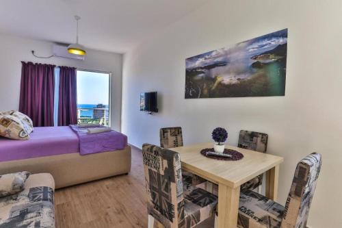 a bedroom with a bed and a table and chairs at Buskovic Bella Vista in Dobra Voda