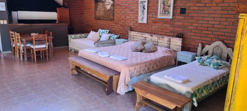 a room with two beds and a brick wall at Nada de Tucanes. Piscina Loft in Posadas