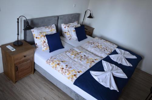 1 dormitorio con 1 cama con edredón azul y blanco en Kerekerdő Vendégház, en Kisszékely