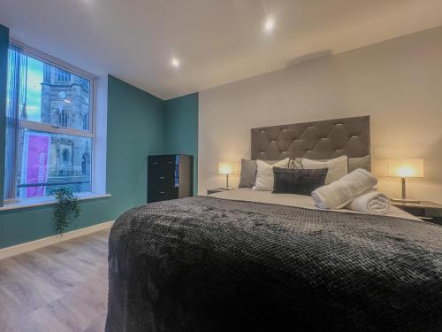 a bedroom with a large bed and a window at Orange Rentals-City Centre - High Spec - The Aqua Suite, Sleeps 4 in Liverpool