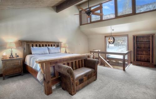 a bedroom with a bed and a chair and a window at Tamarron Gambel Oak - 731 in Durango