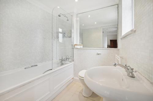 a bathroom with a sink and a tub and a toilet at Close to Kensington palace located double room in London